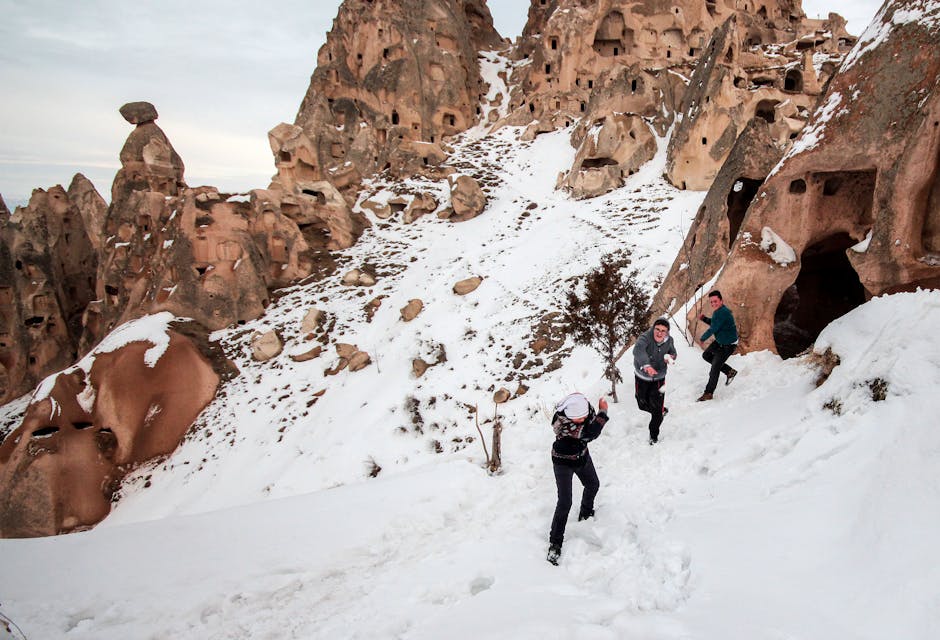 People enjoying winter in the snow-covered fairy chimneys of Cappadocia, Turkey.