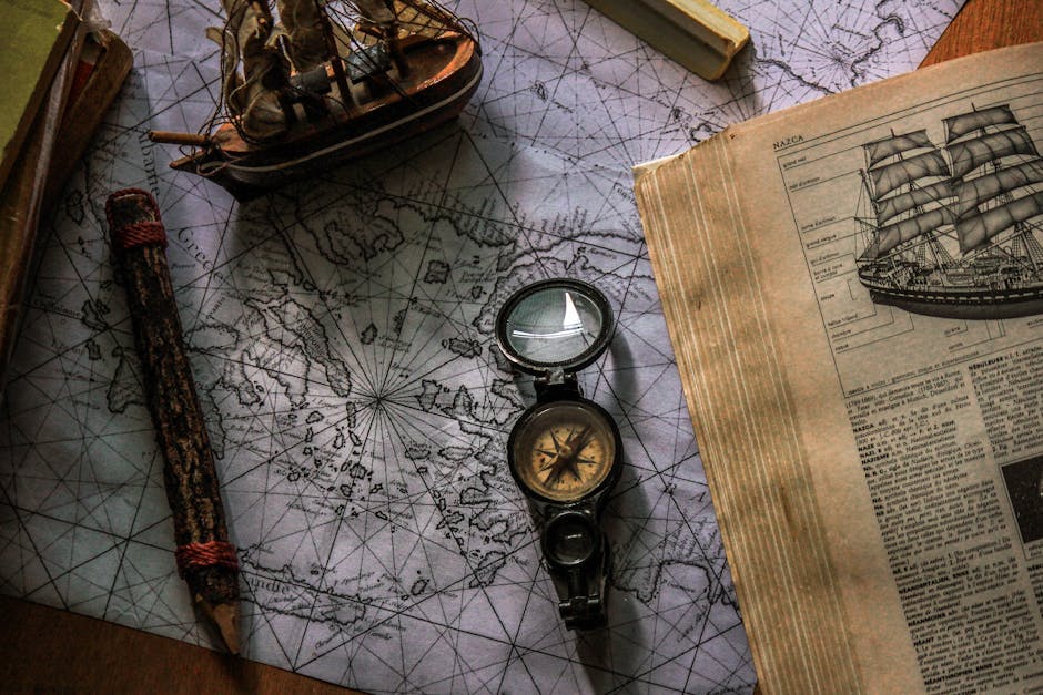 Old map and compass with book and ship model, evoking travel and exploration.